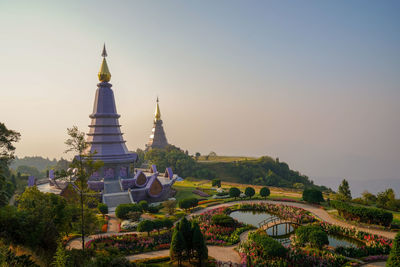 Temple by building against clear sky