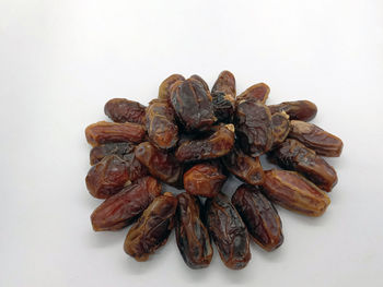 High angle view of roasted coffee beans against white background