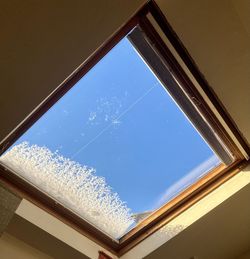 Low angle view of glass window against sky
