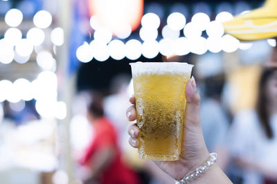 Close-up of hand holding beer glass