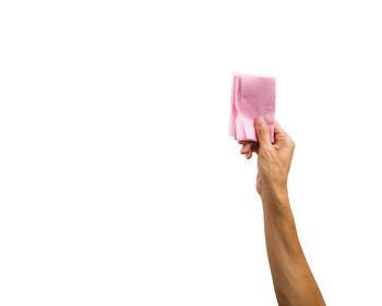 Close-up of hand holding paper against white background