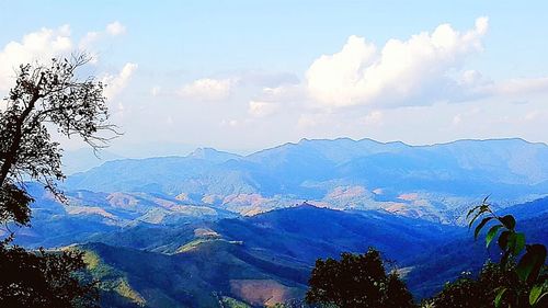 Scenic view of mountain range against cloudy sky