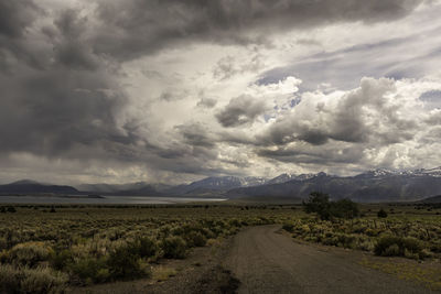 Dirt road along landscape against sky