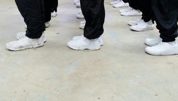 Low section of men standing on concrete ground