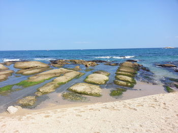 Scenic view of beach against clear blue sky