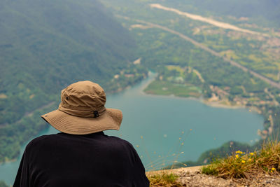 Rear view of person on cliff by lake
