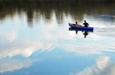 High angle view of man and girl on boat on lake 