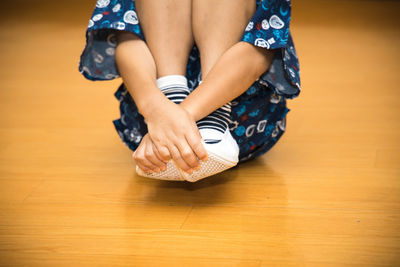 Low section of woman sitting on floor