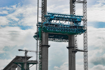 Low angle view of crane against sky