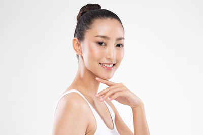 Portrait of young woman against white background