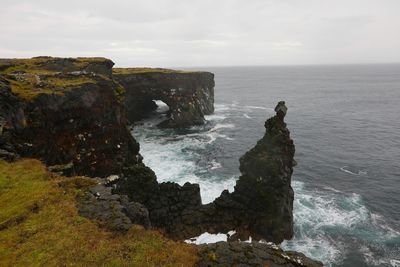 Rock formation in sea against sky