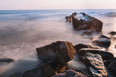 Scenic view of rocks in sea against sky