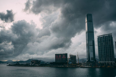 Modern buildings in city against cloudy sky