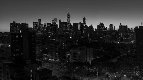 Illuminated buildings in city against sky at night