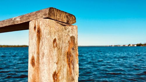 Close-up of wooden post against sea