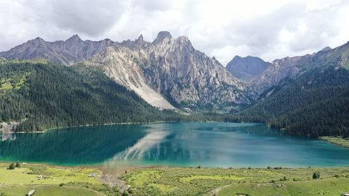 Scenic view of lake by mountains against sky