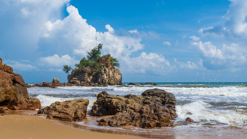 Rocks on beach against sky