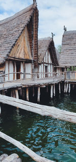 Houses by lake against sky