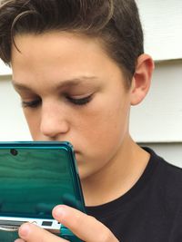 Close-up of boy using mobile phone at home