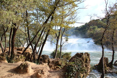 Scenic view of waterfall against sky