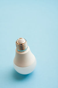 White light bulb standing upside down on blue background.