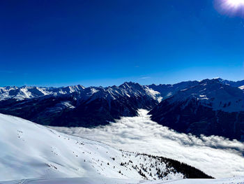 Scenic view of snowcapped mountains against clear blue sky