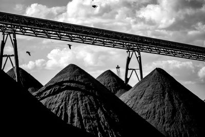 Low angle view of silhouette bridge against sky and coal mountains