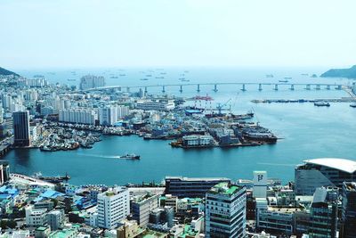 High angle view of city by sea against clear sky