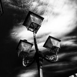 Low angle view of illuminated street light against sky