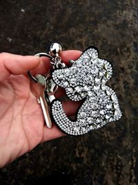 Cropped hand of person holding key with decorated ring