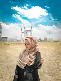 Woman standing on field against sky