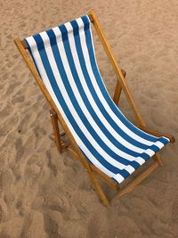 Empty chair on sand at beach