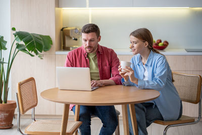 Young woman using laptop at table