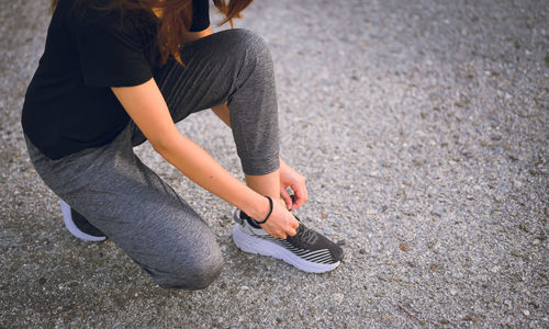 Young women knee sitting and wrapping a shoelace , workout , inspiration and motivation concept