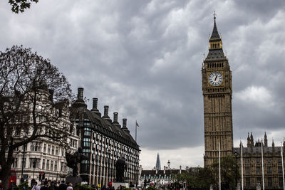 Low angle view of clock tower against cloudy sky