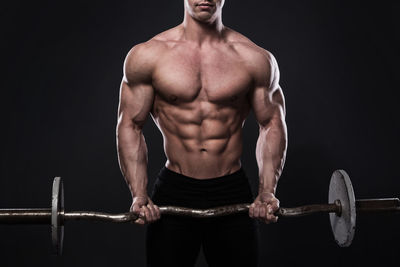 Shirtless man exercising in gym