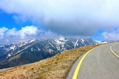 Road leading towards mountain against sky