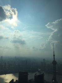 View of cityscape against cloudy sky