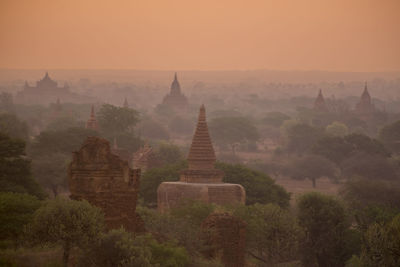 Stupas against orange sky during sunset