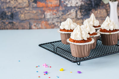 Carrot cake cupcakes with cream cheese frosting with sprinkles. close up. copy space.