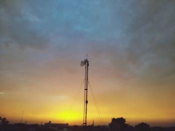 Low angle view of silhouette cranes against sky during sunset