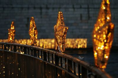 Close-up of illuminated decoration on railing at night