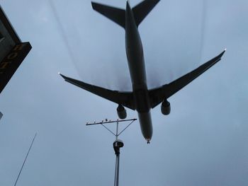 Low angle view of airplane flying against sky