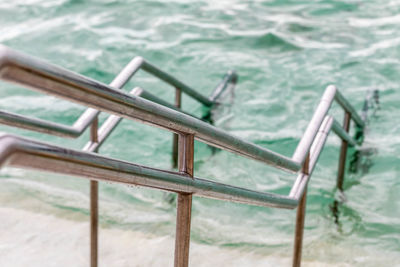 Close-up of empty bench in swimming pool