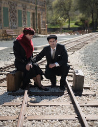 Couple with suitcase on railroad track