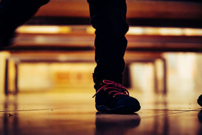 Low section of man standing on tiled floor