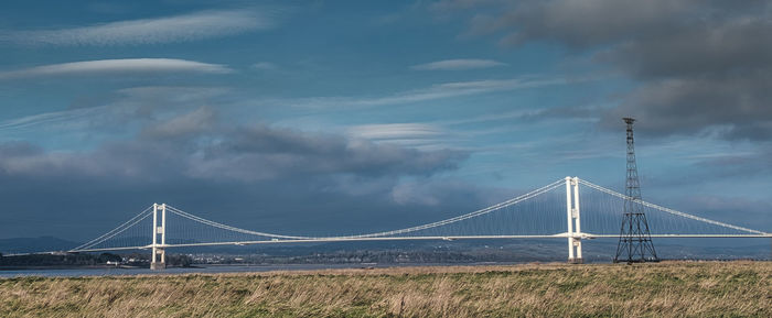View of suspension bridge against cloudy sky