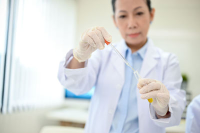 Female doctor examining chemical in laboratory