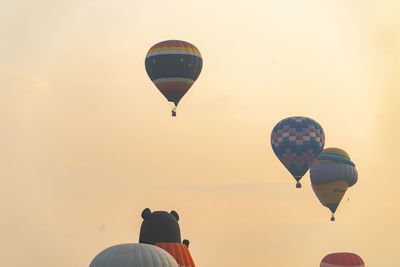 Low angle view of hot air balloons against sky during sunset