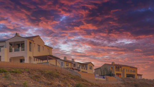 Low angle view of buildings against sky during sunset